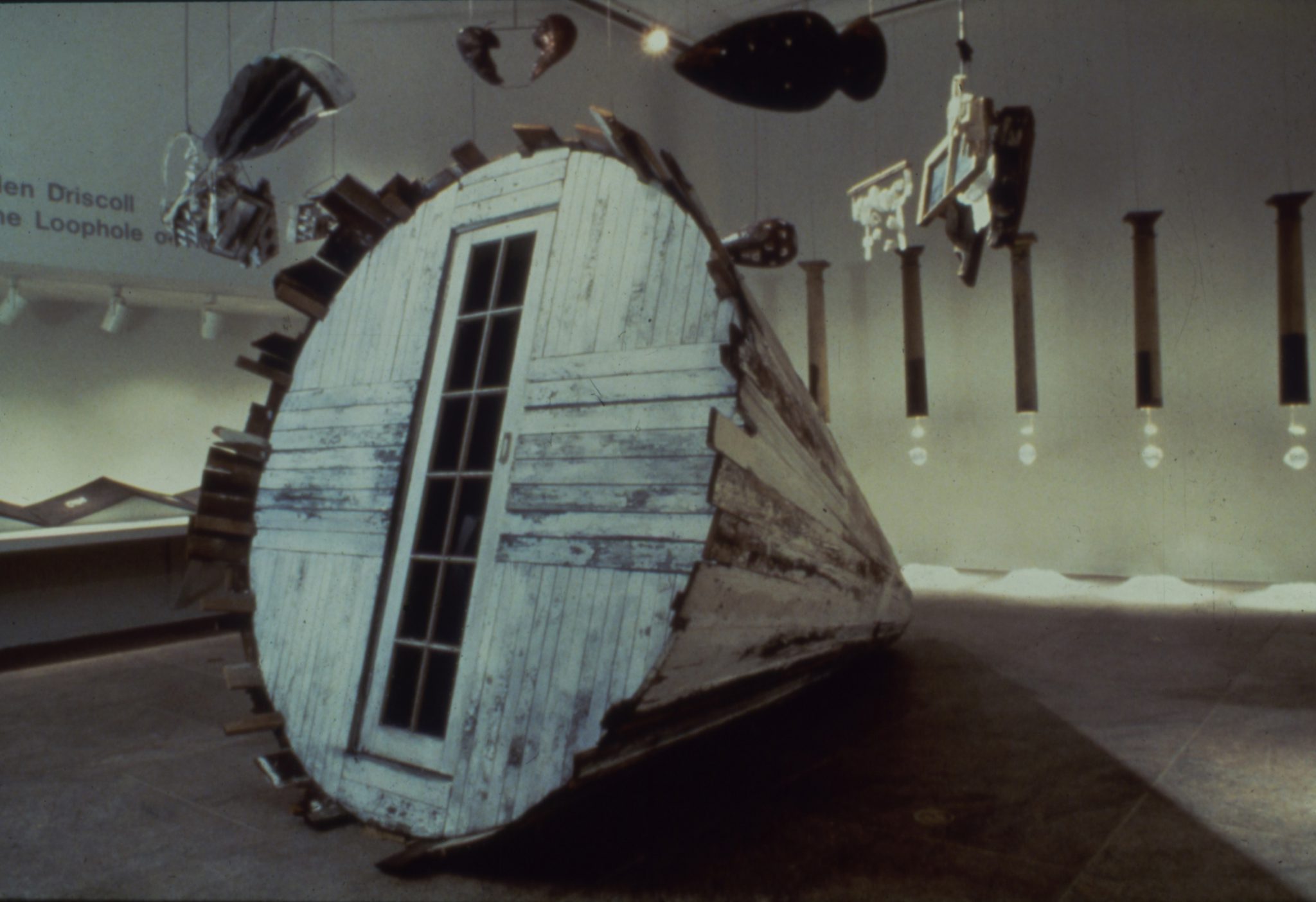 Ellen Driscoll, The Loophole of Retreat, 1990–91. 13’ x 8’ diameter wooden cone, 12 mixed media objects on motorized wheel, 7 suspended columns with interior lights receiving shadow images on salt piles on the floor, and a 22’ x 22” accordion book. Photo by George Hirose.
