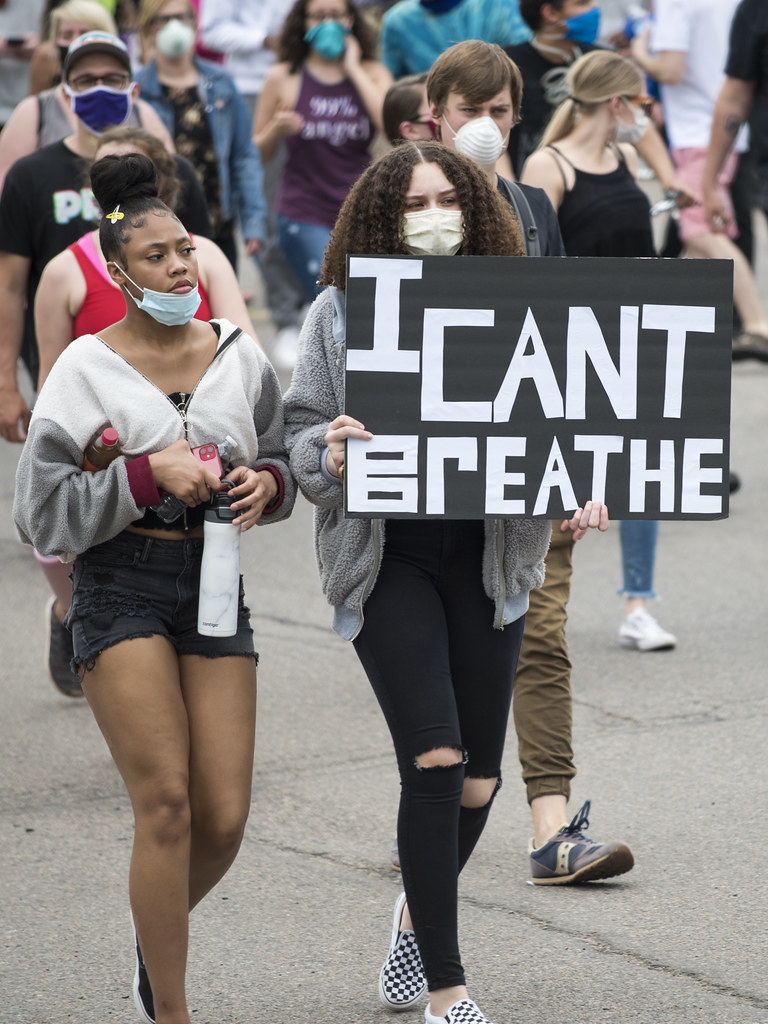 Women hold sign that says I can't breathe
