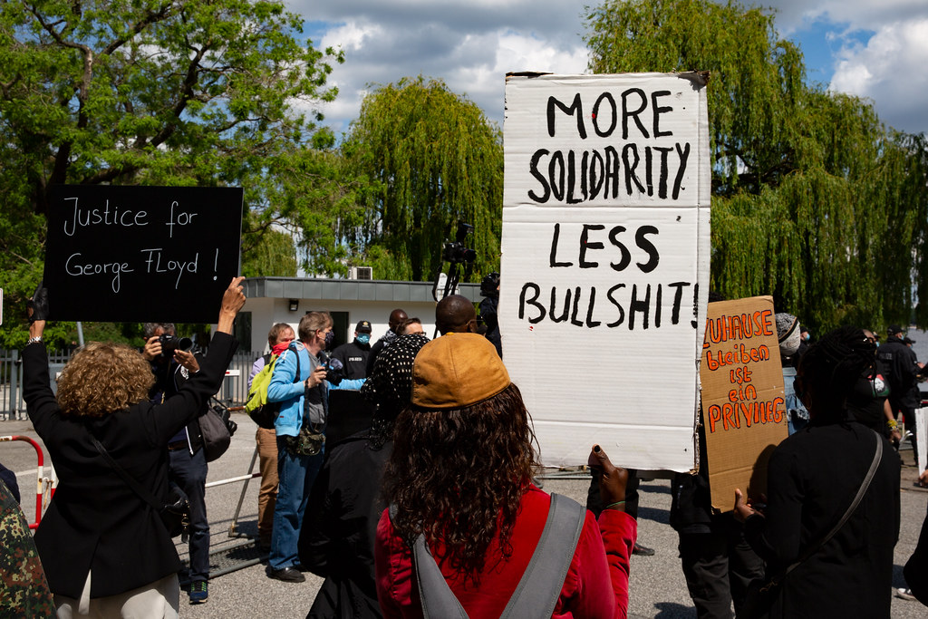 A protest sign that reads "More solidarity, less bullshit"